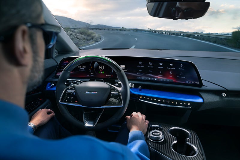 Front View of the 2026 OPTIQ-V Driving Through the Dusk Utilizing its Headlights | Bentley Cadillac Huntsville in Huntsville AL