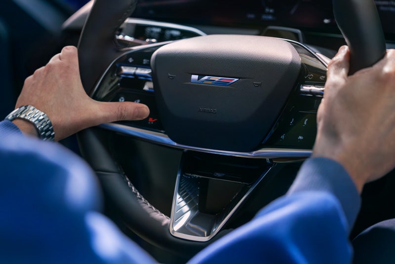 Close-up of a Man About to Press the V-Button on the 2026 OPTIQ-V Steering Wheel | Bentley Cadillac Huntsville in Huntsville AL